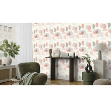 Woonkamer met behang met patroon, fauteuil en tafeldecoratie.