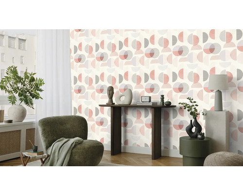 Woonkamer met behang met patroon, fauteuil en tafeldecoratie.