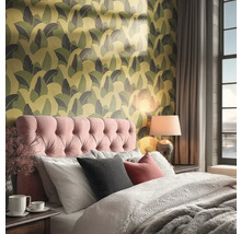 Slaapkamer met bed, nachtlamp en behang met motief