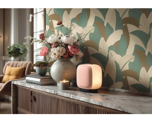 Moderne kamer met behang met groot bladmotief. Op een dressoir met marmeren blad staan een tafellamp, een vaas met bloemen en decoratie.