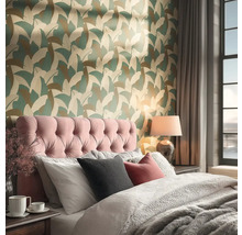 Slaapkamer met behang met bladmotieven, gecapitonneerd hoofdbord en beddengoed met textuur.