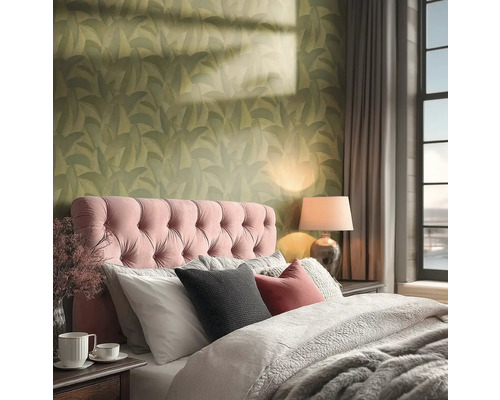 Een gezellige slaapkamer met groen behang met bladpatroon, een roze gecapitonneerd hoofdbord en warme verlichting van een tafellamp.