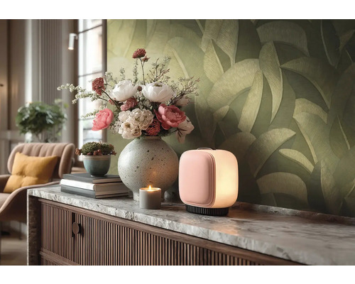 Moderne, kubusvormige tafellamp met zacht licht op een dressoir met marmeren blad, boeket bloemen in vaas en behang met bladmotief.