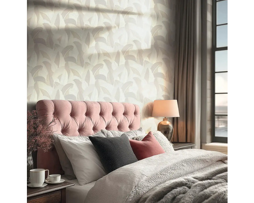 Behang met abstract bladpatroon in een lichte slaapkamer met gecapitonneerd hoofdbord en venster.