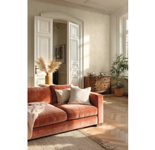 Lichte woonkamer met terracotta fluwelen bank, houten visgraatparket, witte openslaande deuren en een massief houten ladekast.