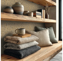 Rustieke houten plank en wand met getextureerd behang, decoratieve vazen, kussens en gestapelde dekens in een gezellige woonruimte.