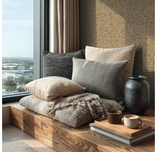 Houten vensterbank met sierkussens, gestructureerde deken, donkere vaas en gestructureerd behang.