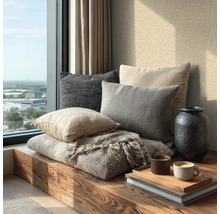 Lichte, moderne vensternis met houten bank, diverse stoffen kussens, een deken, een vaas en koffiekopjes op een dienblad.