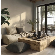 Lichte, minimalistische woonruimte met een lage stoffen bank, een salontafel van een massief houten blok en grote terrasramen.