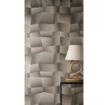 Behang met driedimensionaal geometrisch patroon en gestructureerd oppervlak, gecombineerd met een tafellamp met touwvoet op een bijzettafel.