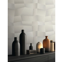 Modern structuurbehang met driedimensionaal polygoonpatroon in lichtgrijs, gedecoreerd met diverse vazen op een dressoir.