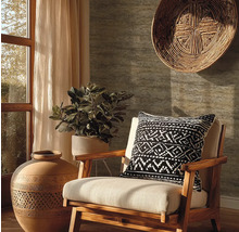 Woonkamer met houten fauteuil, sierkussen met motief, potplant, decoratieve vaas en wandmand