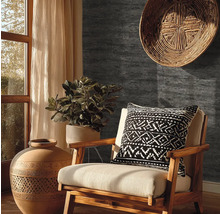 Donkergrijs behang met steenlook in een rustiek ingerichte woonkamer met houten stoel, terracotta vaas en kamerplant.