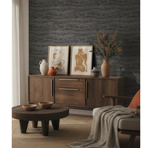 Georganiseerde woonkamer met getextureerd behang, een houten dressoir, een ronde salontafel, decoratieve vazen en ingelijste afbeeldingen.