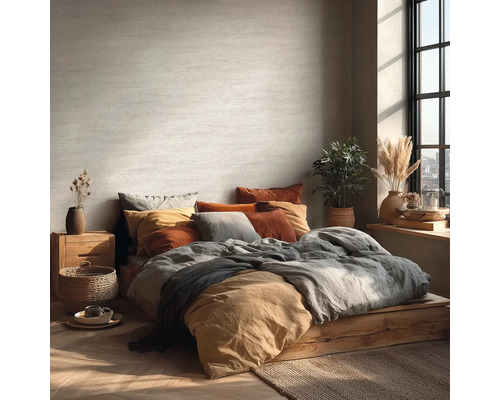 Lichte slaapkamer met bed op houten platform, veel kussens en kamerplanten.