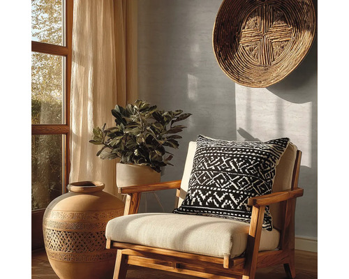 Decoratief interieur met een stoel, een kussen met geometrisch patroon, een grote vaas en een kamerplant.