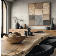 Eetkamer met houten tafel, schaal, servies, decoratie en kunstwerk aan de muur