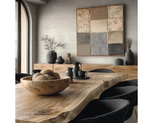 Eetkamer met houten tafel, schaal, servies, decoratie en kunstwerk aan de muur