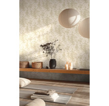 Vliesbehang met fijnmazig boompatroon in een lichte kamer met yogamatten, houten elementen, gevlochten manden en papieren hanglampen.