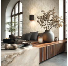 Lichte woonkamer met patroonbehang, wandlamp, houten dressoir met lamellen en grote stenen vaas met droge takken.