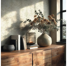 Houten dressoir met keramische vaas, droogbloemen, glazen windlicht met brandende kaars, boeken en decoratieve schaal voor een licht patroonbehang.