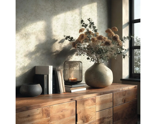 Houten dressoir met keramische vaas, droogbloemen, glazen windlicht met brandende kaars, boeken en decoratieve schaal voor een licht patroonbehang.