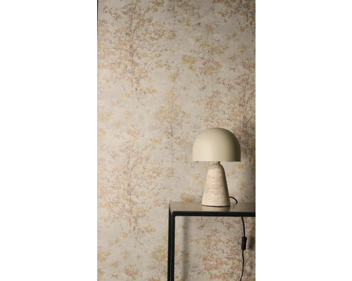 Vliesbehang met discreet boompatroon achter een moderne tafellamp met stenen voet op een eenvoudige consoletafel.