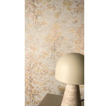 Vliesbehang met impressionistisch boommotief in goud en roze op een lichte achtergrund, gecombineerd met een moderne tafellamp.