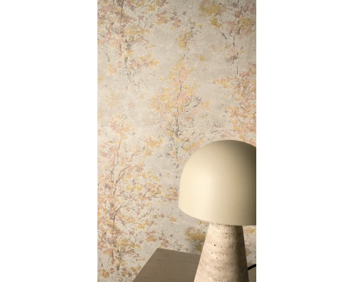 Vliesbehang met impressionistisch boommotief in goud en roze op een lichte achtergrund, gecombineerd met een moderne tafellamp.