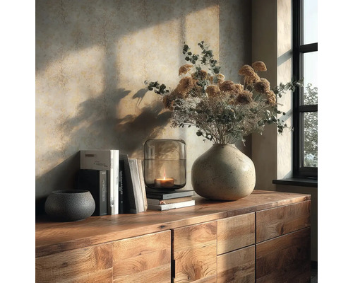 Houten dressoir met stenen vaas, droogbloemen, glazen lantaarn met kaars en boeken voor gestructureerd behang in warm zonlicht.