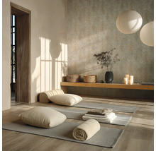 Heldere yogaruimte met grijze matten op een houten vloer, kussens, handdoeken, een houten bank en ronde papieren lantaarns.