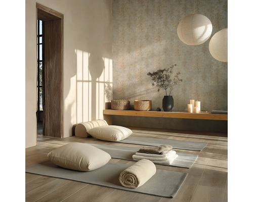 Heldere yogaruimte met grijze matten op een houten vloer, kussens, handdoeken, een houten bank en ronde papieren lantaarns.