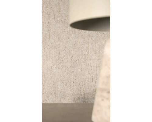 Gestructureerd vliesbehang met verticaal patroon en glittereffect achter een lamp.