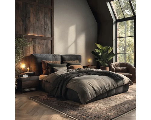 Modern rustieke slaapkamer met gestoffeerd bed, houten wandpanelen, leren fauteuil, grote groene plant en visgraatparket.