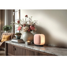 Moderne draagbare LED-lamp, stenen vaas met bloemen en een kaars op een dressoir met marmeren blad in een lichte woonkamer.