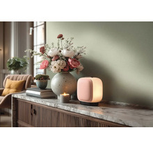 Moderne woonkamerscène met een brandende draagbare tafellamp en een grote bloemenvaas op een dressoir met marmeren blad.