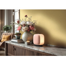 Moderne tafellamp op een dressoir met marmeren blad, daarnaast een bloemenvaas, een kleine plantenpot en een brandende kaars.