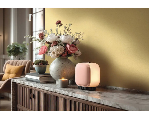 Moderne tafellamp op een dressoir met marmeren blad, daarnaast een bloemenvaas, een kleine plantenpot en een brandende kaars.