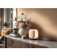 Decoratief interieur met tafellamp, bloemstuk en kaars op een dressoir.