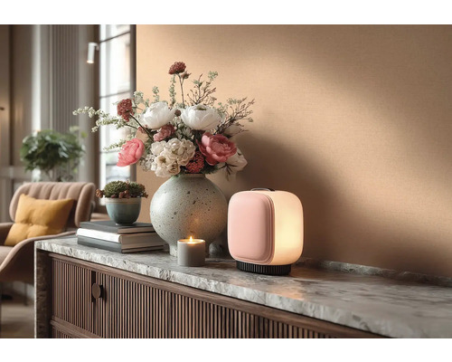 Decoratief interieur met tafellamp, bloemstuk en kaars op een dressoir.