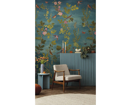 Decoratieve woonkamer met bloemenbehang, fauteuil, bijzettafel en radiatorbekleding.