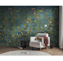 Interieurvoorbeeld met bloemenbehang, fauteuil, staande lamp en bijzettafel voor een stijlvolle woonsfeer.