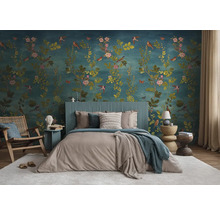 Slaapkamer met gedessineerd behang, bed, stoelen en bijzettafels voor een lichte en georganiseerde sfeer