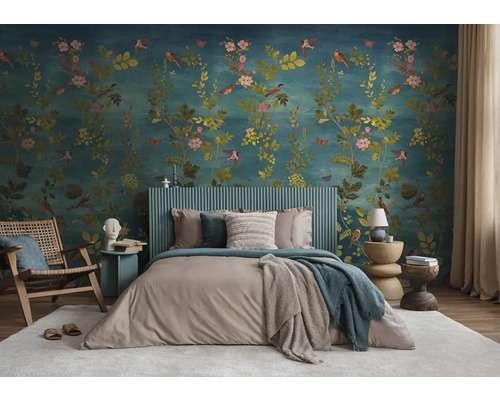 Slaapkamer met gedessineerd behang, bed, stoelen en bijzettafels voor een lichte en georganiseerde sfeer