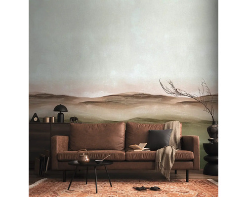 Woonkamer met bruine leren bank, kleine tafel, vloerkleed en behang met patroon