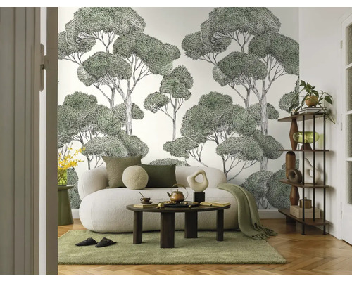 Woonkamer met bank, salontafel, plank en behang met boommotief