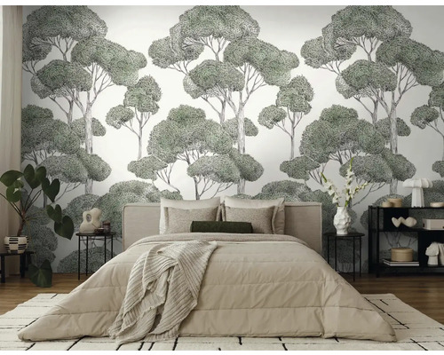 Slaapkamer met een wandbekleding met een boommotief achter een bed.