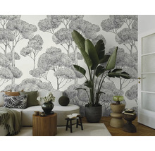 Lichte woonkamer met bank, kamerplant en behang met boommotief