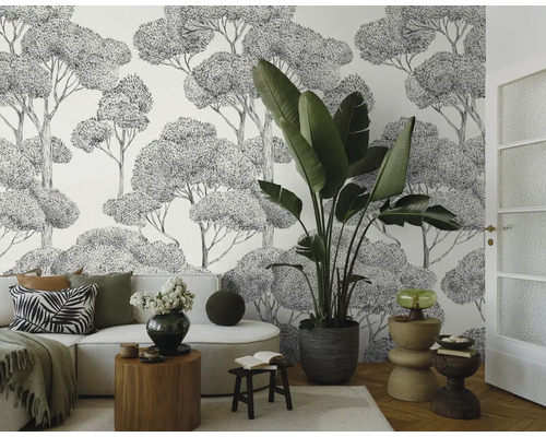 Lichte woonkamer met bank, kamerplant en behang met boommotief