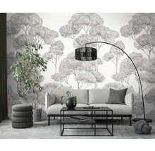 Woonkamer met bank, salontafel, vloerlamp, kamerplant en behang met boommotief